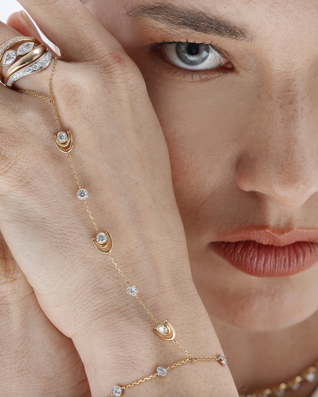 Close-up editorial portrait featuring the Zorae hand chain and sculptural rings
